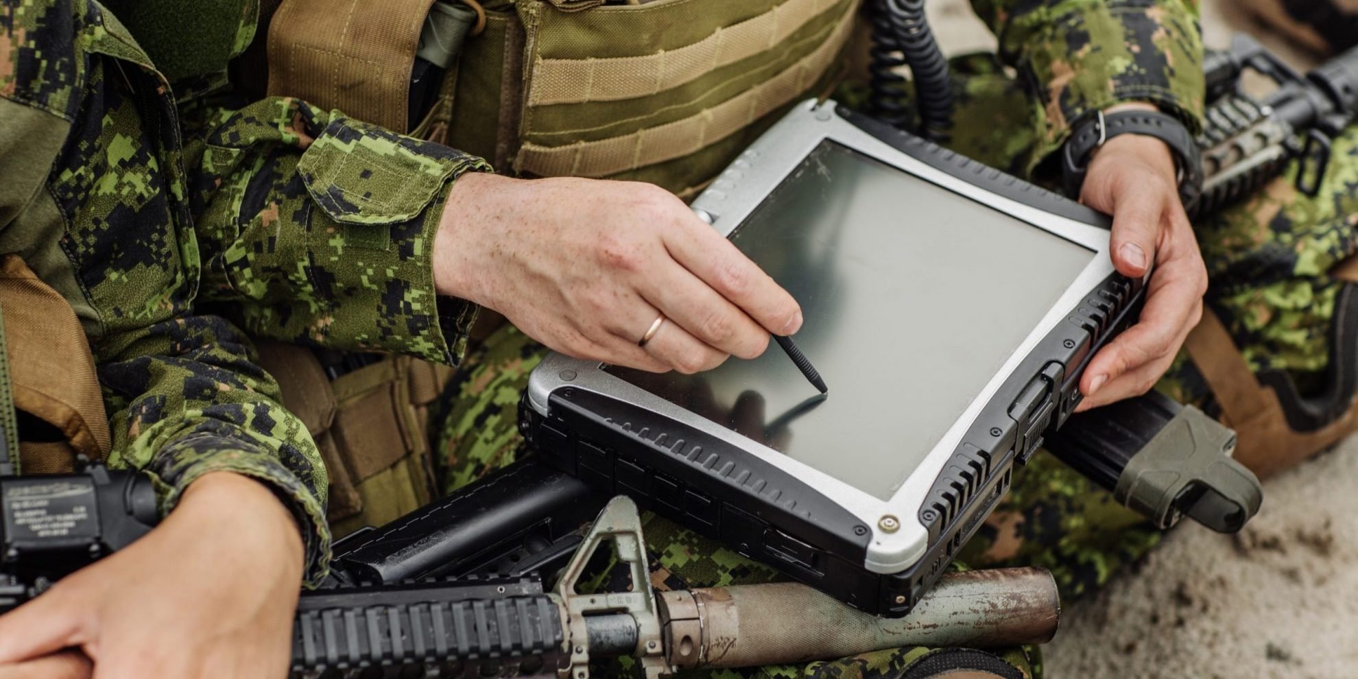 Closeup of soldier with tablet illustrates blog "What Is the Difference Between CMMC and NIST SP 800-171? "