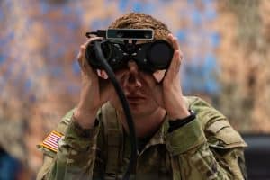 U.S soldier using binoculars illustrates blog "CMMC vs. FedRAMP: What Is the Difference? "